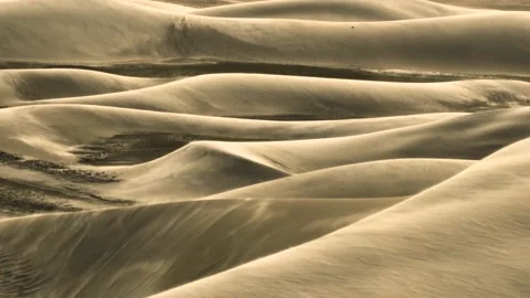Strong wind blows sand over surface of dunes, aerial trucking - nature Video stock 221212711