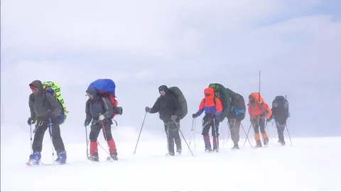 Strong wind mountaineers climb the mountain. Motivation. Stock Footage