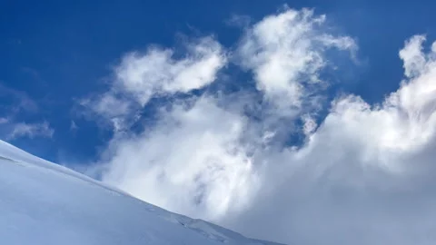 Strong wind move fast flying white clouds over snowy slope Kazbek (Kazbegi) summ Stock-Footage 260071933