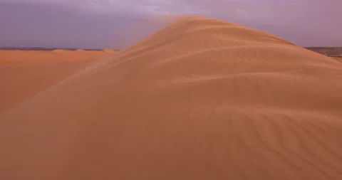 Strong wind at sunset over the sand dunes in the desert. Sandstorm in the Desert Stock Footage 168175543