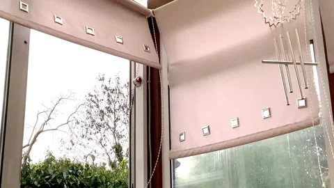 Strong wind through a door blowing window blinds and hanging chimes. Stock Footage 271149386