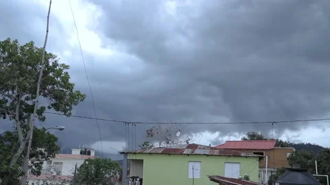 Strong wind time lapse. dramatic clouds moving by a heavy wind with some hous Stock Footage 130986914