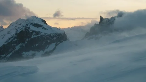 Strong winds blowing snow on mountain summit after sunset, Swiss Alps Stock Footage 129090221