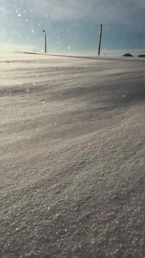 Strong winter wind blows snowflakes down a hill Stock Footage 165238773