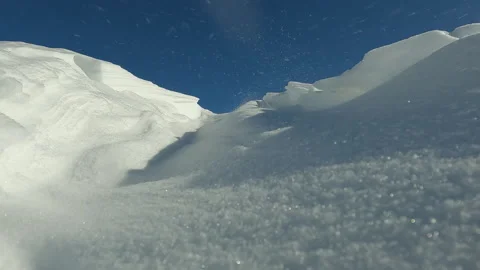 Strong winter winds blow large snow drift off mountaintop at an altitude. Snow Stock-Footage 245521665