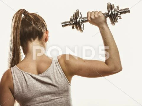 Strong woman lifting dumbbells weights. Fitness. Stock Photos