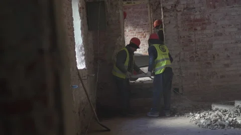 Strong workers in hardhats carry massive concrete slab Видео 314649005