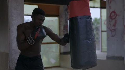 Strong young boxer hitting boxing bag Stock Footage 115719807