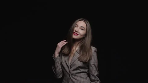 A strong young brunette in a jacket feels happy stroking herself and posing  Stock Footage 195612853