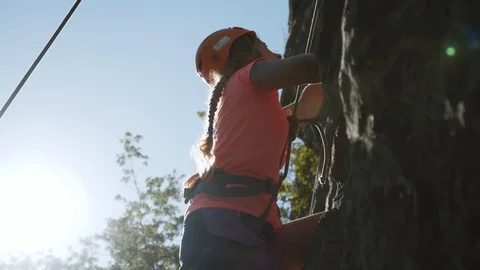 Strong young girl climbing rock trying hard. Sports outdoors in summer. Stock Footage
