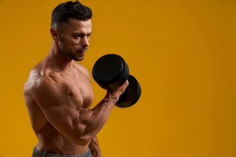 Strong young man doing exercise with dumbbell Stock Photos
