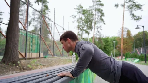 Strong young man doing push ups on sports ground Stock Footage 257821194