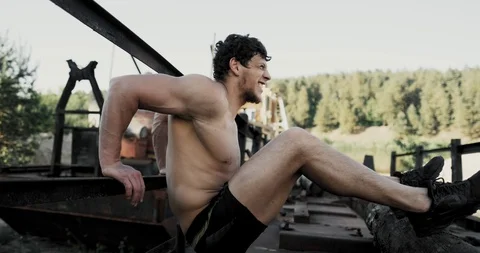 Strong young man is doing triceps dips on parallel bars. Exercising outdoors in 動画素材 109206839