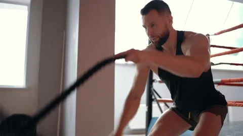 The strong young man, pressed by the intensity of the exercise, executes with Stock Footage 156475359