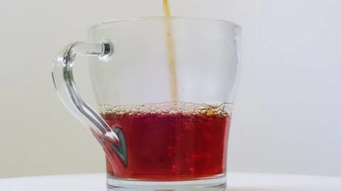 Strongly brewed tea is poured into a transparent mug in a thin stream. Medi.. Stock Footage 283769602