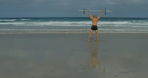 A Strongman doing Barbell Presses on a Beach. Vídeo Stock 85513587