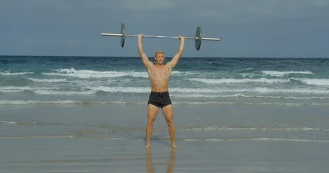 A Strongman doing Crossfit weights on a beach. Vídeo Stock 85513480