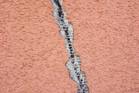 Structural Crack on Building Facade with Ruptured Reinforcement Mesh and Damaged Stock Photos