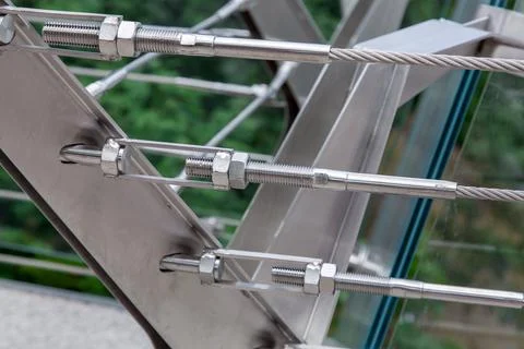 Structural details of iron mounts of frameless glass bridge close up. Stock Photos