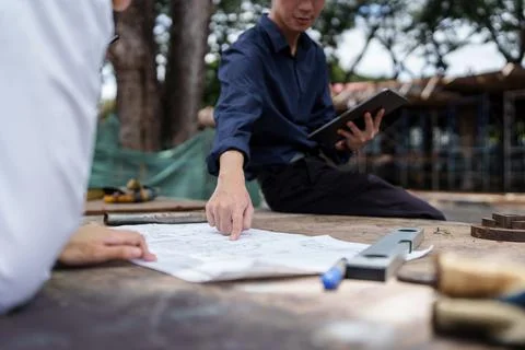 Structural engineer and architect discussing and working with blueprints at the Stock Photos