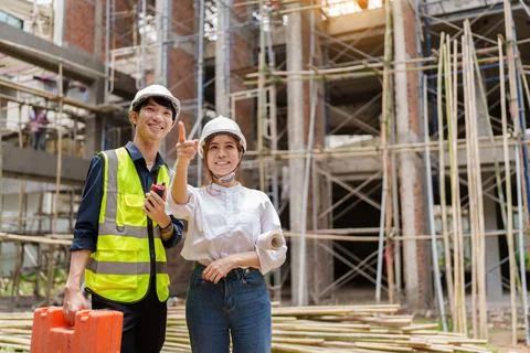 Structural engineer and architect discussing and working with blueprints at the Stock Photos