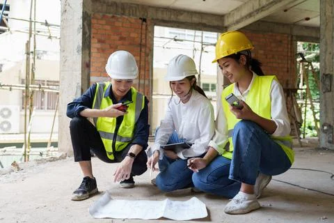Structural engineer and architect discussing and working with blueprints at the Stock Photos