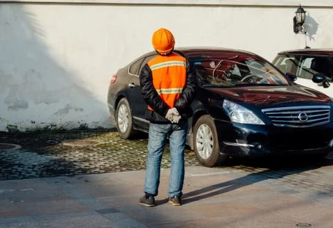 Structural engineer in orange work vests and hard bats looking up building re Stock Photos