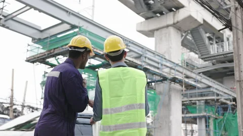 Structural engineers and construction workers are holding blueprints inspecting  Stock Footage 222543446