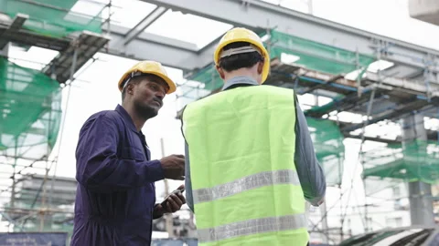 Structural engineers and construction workers are holding blueprints inspecting  Stock Footage 222546184