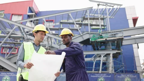 Structural engineers and construction workers are holding blueprints inspecting  Stock Footage 222548707