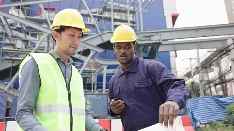 Structural engineers and construction workers are holding blueprints inspecting  Stock Footage 222549844