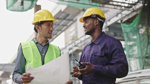 Structural engineers and construction workers are holding blueprints inspecting  Stock Footage 224507088