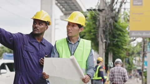 Structural engineers and construction workers are holding blueprints inspecting  Stock Footage 224508777