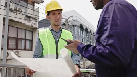 Structural engineers and construction workers are holding blueprints inspecting  Stock Footage 225290138