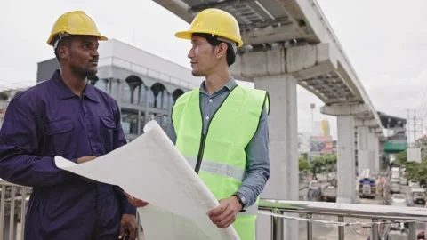 Structural engineers and construction workers are holding blueprints inspecting  Stock Footage 225290148