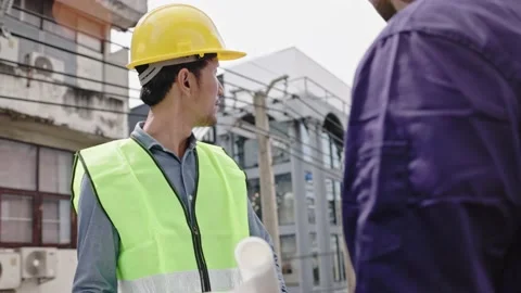 Structural engineers and construction workers are holding blueprints inspecting  Stock Footage 225290152