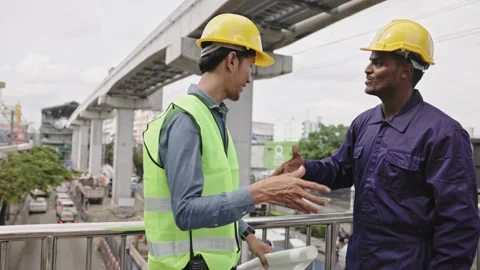 Structural engineers and construction workers are holding blueprints inspecting  Stock Footage 225290198