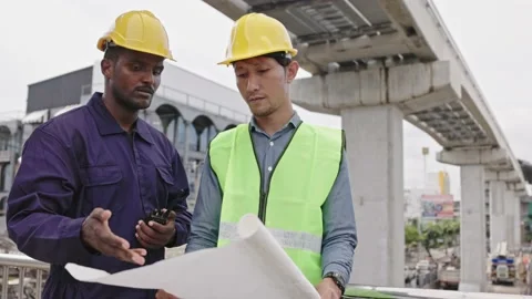 Structural engineers and construction workers are holding blueprints inspecting  Stock Footage 225290205
