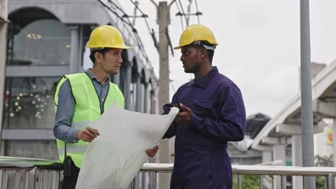 Structural engineers and construction workers are holding blueprints inspecting  Stock Footage 225290241