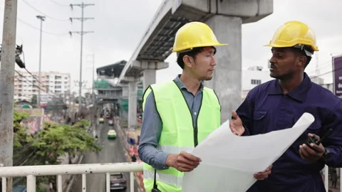 Structural engineers and construction workers are holding blueprints inspecting  Stock Footage 228388886