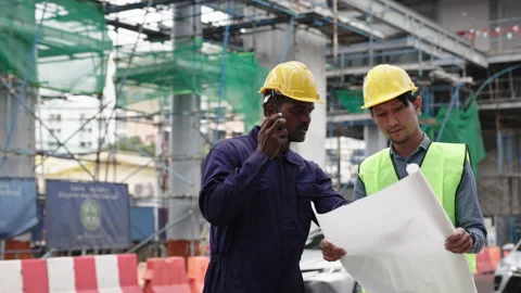 Structural engineers and construction workers are holding blueprints inspecting  Stock Footage 228390295