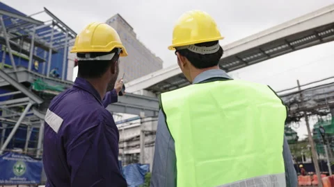 Structural engineers and construction workers are holding blueprints inspecting  Stock Footage 228391150