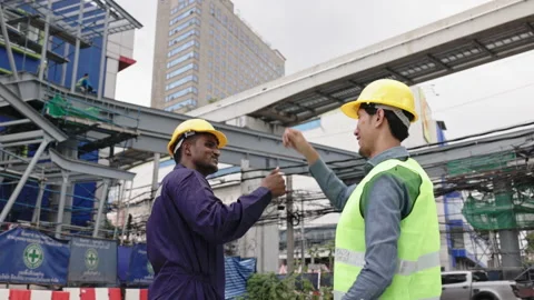 Structural engineers and construction workers are holding blueprints inspecting  Stock Footage 228391347