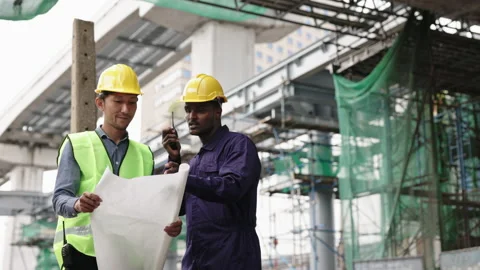 Structural engineers and construction workers are holding blueprints inspecting  Stock Footage 228391538