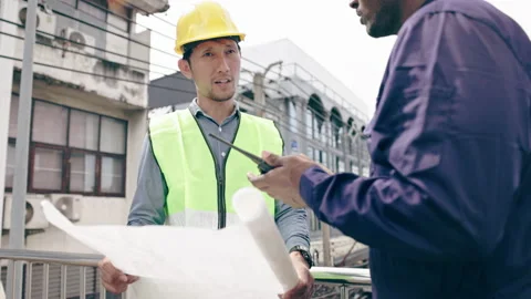 Structural engineers and construction workers are holding blueprints inspecting  Video stock 235606334