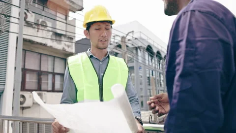 Structural engineers and construction workers are holding blueprints inspecting  Video stock 235606421