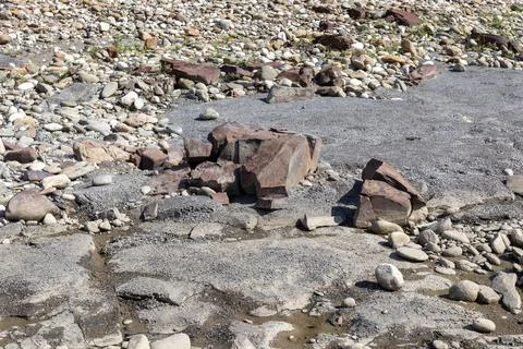 The structure of the bottom is a shallow mountain river, an old man and natur Stock Photos