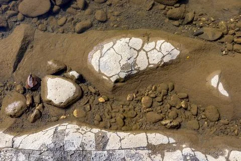 The structure of the bottom is a shallow mountain river, an old man and natur Stock Photos