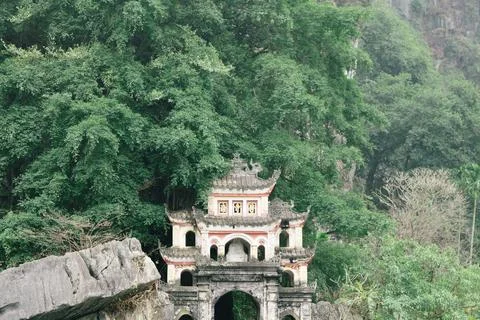 The structure of a building is visible, with lush trees behind it Ninh Binh.. Fotos de archivo