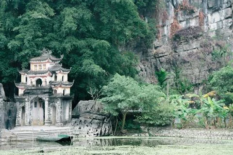 The structure of a building is visible, with lush trees behind it Ninh Binh.. Stock Photos